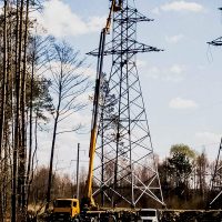 Автовышка ведет работы на башне электропередач