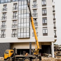 Высотные работы на новом здании многоэтажки при помощи автовышки