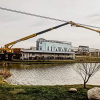 Автовышка производит монтаж над водоемом