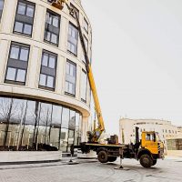 Работы на высоту у многоэтажки при помощи автовышки